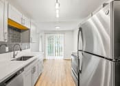 Thumbnail 24 of 42 - a kitchen with white cabinets and stainless steel appliances