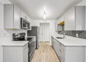 Thumbnail 23 of 42 - a kitchen with white cabinets and stainless steel appliances