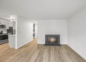 Thumbnail 20 of 42 - a living room with a fireplace and a kitchen in the background