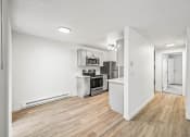 Thumbnail 18 of 42 - a kitchen and living room with hardwood floors and white walls