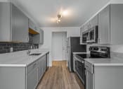 Thumbnail 38 of 42 - a kitchen with gray cabinets and white countertops