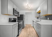 Thumbnail 34 of 42 - a kitchen with white cabinets and a wooden floor