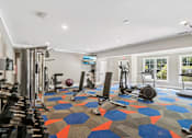 Thumbnail 6 of 35 - A gym with a variety of equipment including weights, a treadmill, and a stationary bike.