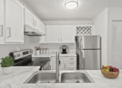 Thumbnail 1 of 20 - a white kitchen with stainless steel appliances and white cabinets