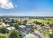 Thumbnail 2 of 22 - A sunny day at a residential complex with a clear blue sky.