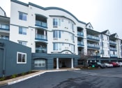Thumbnail 35 of 42 - a large white building with cars parked in front of it