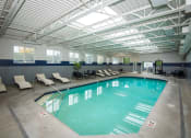 Thumbnail 28 of 42 - a large indoor swimming pool under a ceiling with chairs