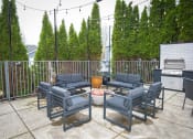 Thumbnail 25 of 42 - the patio has a gas grill and chairs around a fire pit