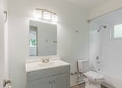 Thumbnail 27 of 28 - A white bathroom with a toilet, sink, and mirror.