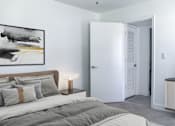 Thumbnail 7 of 20 - a bedroom with a bed and a nightstand with a lamp