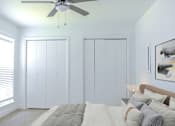 Thumbnail 6 of 20 - a bedroom with a bed and a ceiling fan