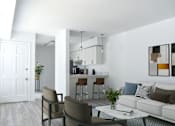 Thumbnail 16 of 20 - a living room with white walls and a white couch with a coffee table in front of it