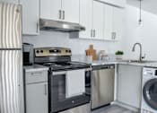 Thumbnail 10 of 20 - a kitchen with white cabinets and stainless steel appliances
