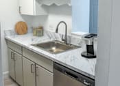 Thumbnail 5 of 20 - a kitchen with white cabinets and a stainless steel sink
