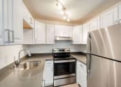 Thumbnail 13 of 24 - a kitchen with white cabinets and stainless steel appliances