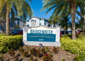 Thumbnail 3 of 43 - the entrance to bridgewater apartments sign in front of palm trees
