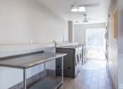 Thumbnail 11 of 43 - an empty laundry room with stainless steel counters and a row of washing machines