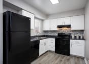 Thumbnail 17 of 43 - an empty kitchen with black appliances and white cabinets