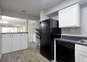 Thumbnail 18 of 43 - the preserve at ballantyne commons apartment kitchen and living room with black refrigerator