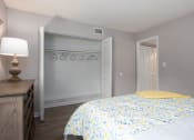 Thumbnail 19 of 43 - a bedroom with a yellow and white bed and a closet