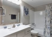 Thumbnail 20 of 43 - a white bathroom with a shower curtain and a white sink and toilet