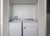 Thumbnail 23 of 43 - an empty laundry room with two washes and a dryer