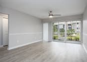 Thumbnail 24 of 43 - an empty living room with a window and a ceiling fan