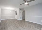 Thumbnail 25 of 43 - an empty living room with wood flooring and a ceiling fan