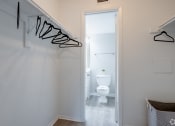 Thumbnail 32 of 43 - a small bathroom with a toilet and a hallway to a closet