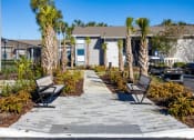 Thumbnail 39 of 43 - a walkway with benches and palm trees in front of houses