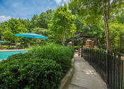 Thumbnail 5 of 34 - a walkway next to a pool with a gazebo and a fence