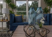 Thumbnail 27 of 34 - a living room with blue couches and a table with vases