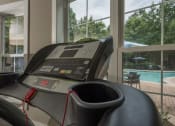Thumbnail 25 of 34 - a treadmill in a gym with a pool in the background