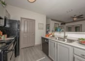 Thumbnail 24 of 34 - a kitchen with white cabinets and a sink and a refrigerator