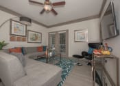 Thumbnail 19 of 34 - a living room with a couch and a ceiling fan