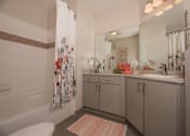 Thumbnail 14 of 34 - a bathroom with a shower and a sink and a toilet