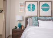 Thumbnail 12 of 34 - a bedroom with a bed and pictures on the wall above it