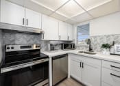 Thumbnail 5 of 33 - a kitchen with white cabinets and black and white appliances