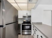 Thumbnail 32 of 33 - a kitchen with stainless steel appliances and white cabinets