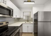 Thumbnail 29 of 33 - a kitchen with stainless steel appliances and white cabinets