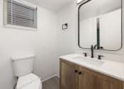 Thumbnail 27 of 33 - an empty bathroom with a toilet sink and mirror