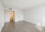 Thumbnail 26 of 33 - an empty living room with white walls and wood flooring