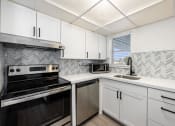 Thumbnail 21 of 33 - a kitchen with white cabinets and black appliances and a sink