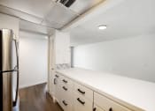 Thumbnail 20 of 33 - an empty kitchen with white cabinets and a stainless steel refrigerator