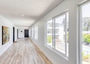 Thumbnail 9 of 24 - a long hallway with large windows and a wooden floor