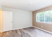 Thumbnail 6 of 9 - a bedroom with hardwood floors and a large window