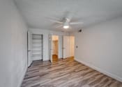 Thumbnail 11 of 36 - a bedroom with a ceiling fan and hardwood floors