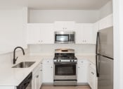 Thumbnail 26 of 42 - a kitchen with white cabinets and stainless steel appliances