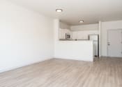 Thumbnail 21 of 42 - an empty living room and kitchen with white walls and wood flooring