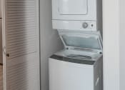 Thumbnail 16 of 42 - a white washer and dryer in a small room with a white door